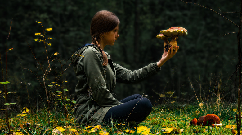 Woman holding mushroom in forest