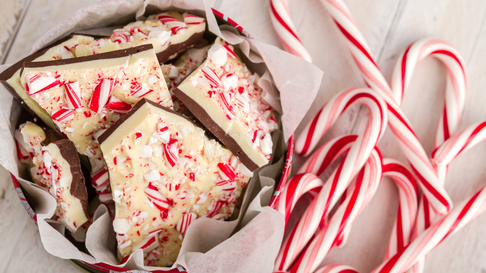 bowl of peppermint bark with candy canes on the side