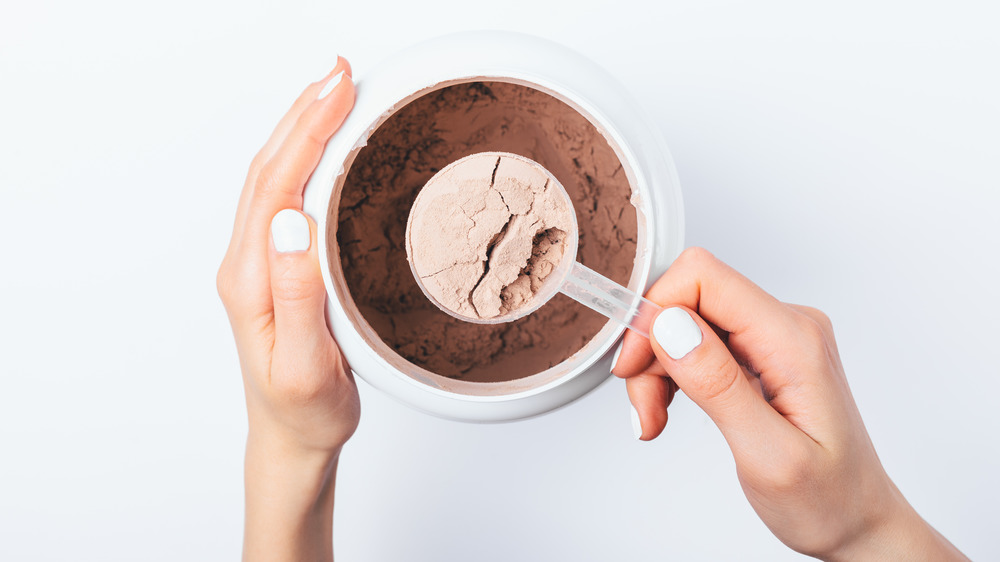 Woman scooping protein powder