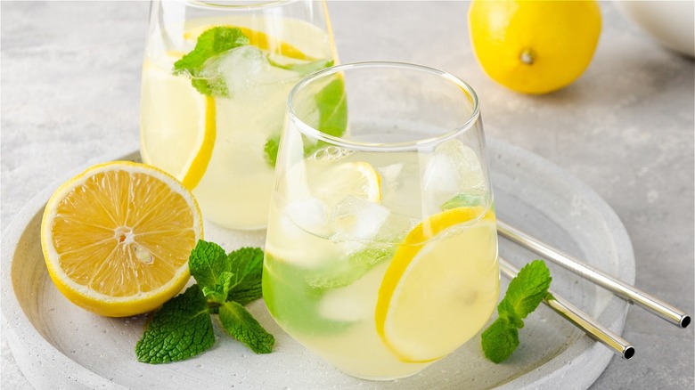 Two glasses of lemonade with lemon slices and garnish