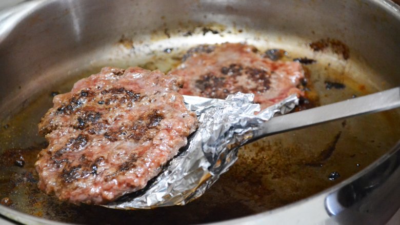 Flipping a burger while it's cooking