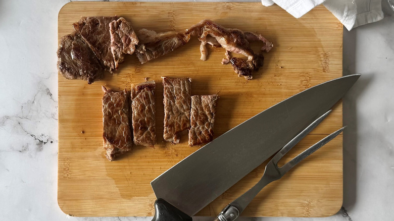 chopped steak and a knife on a wooden board