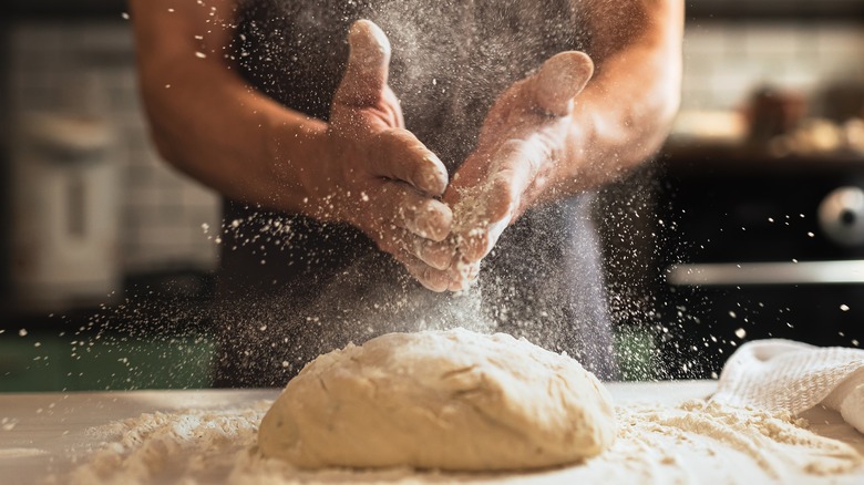 person working bread dough