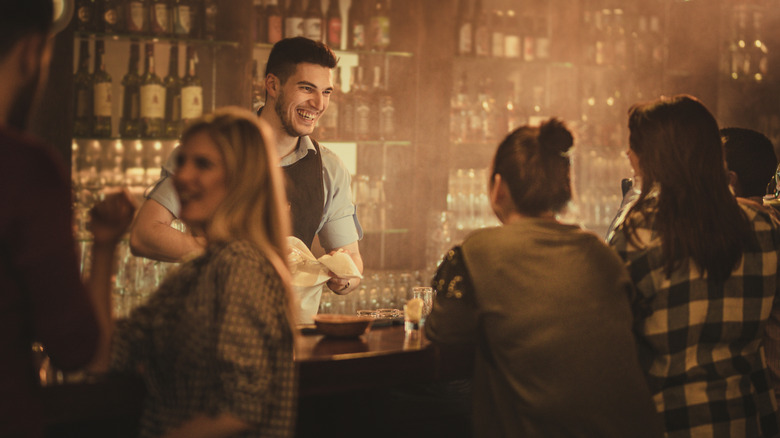 Two women talking to bartender