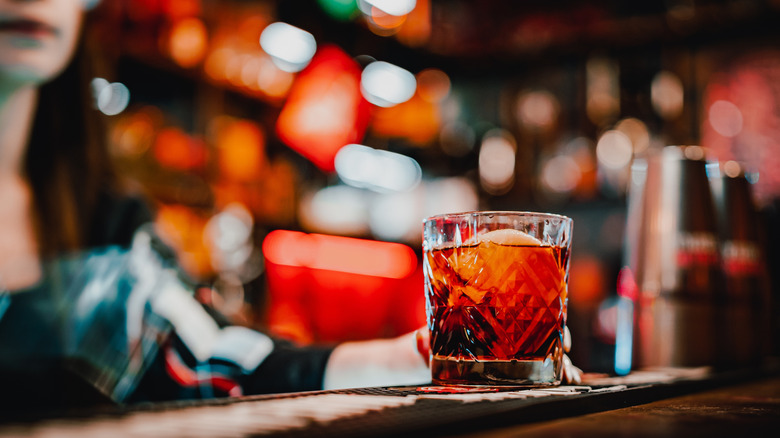 Negroni on bar top with bartender in background