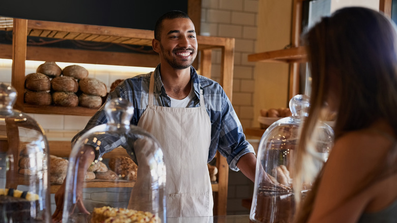 Baker smiling at customer in bakery