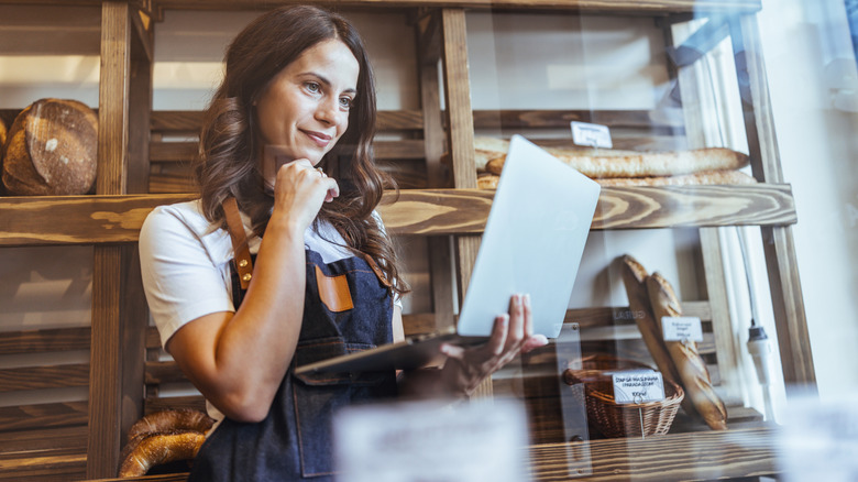 Bakery worker looking at laptop