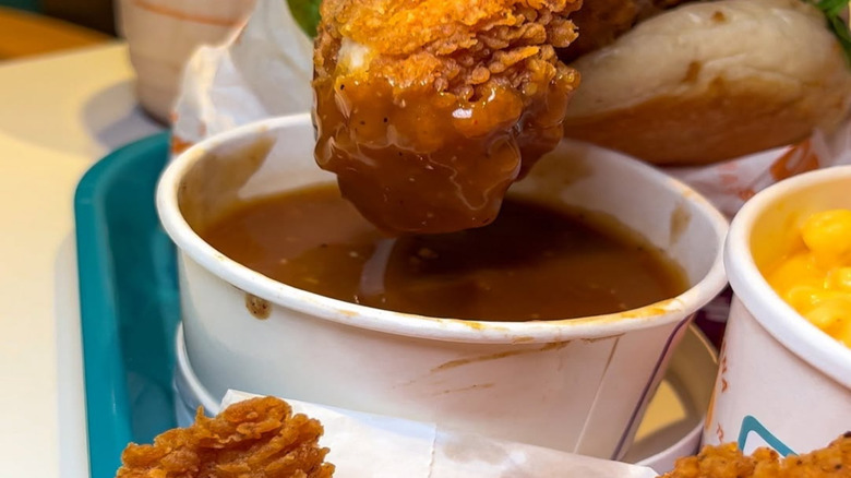 Dipping Popeyes tender into gravy