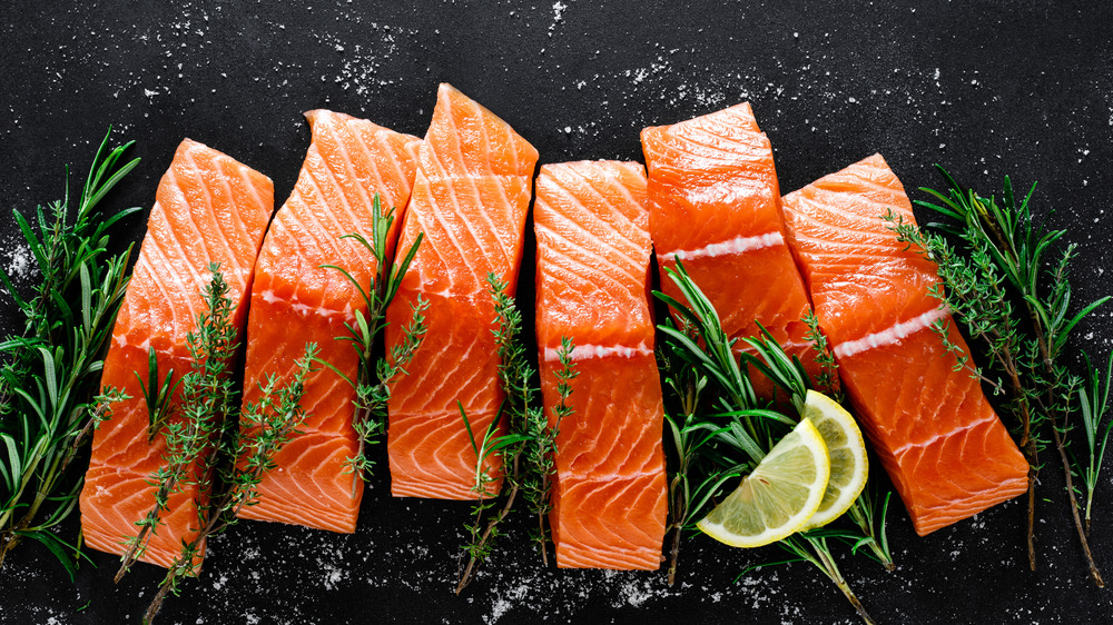 Pieces of raw salmon with salt and herbs 