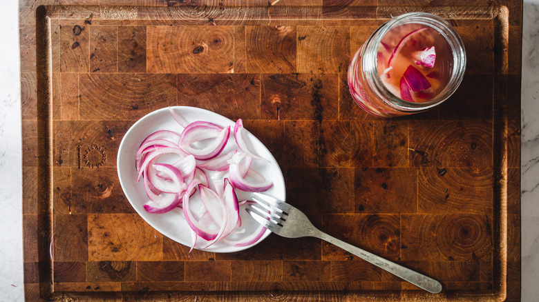 pickled onions on plate with jar