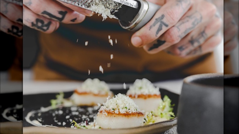 Grating horseradish onto scallop