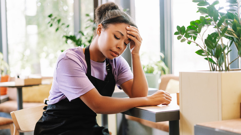 Young server with a sad expression in an apron