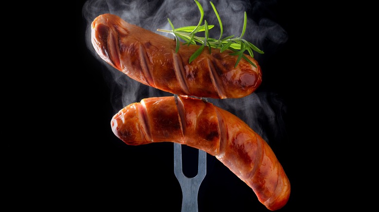 steaming sausages on fork