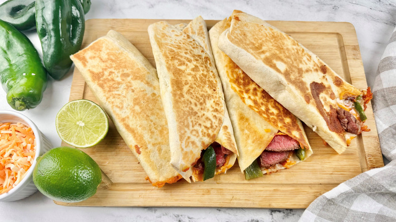Steak and poblano quesadilla wraps on wooden board