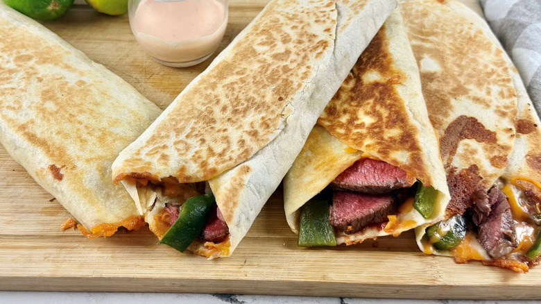 Steak and poblano rolled quesadillas on wooden board