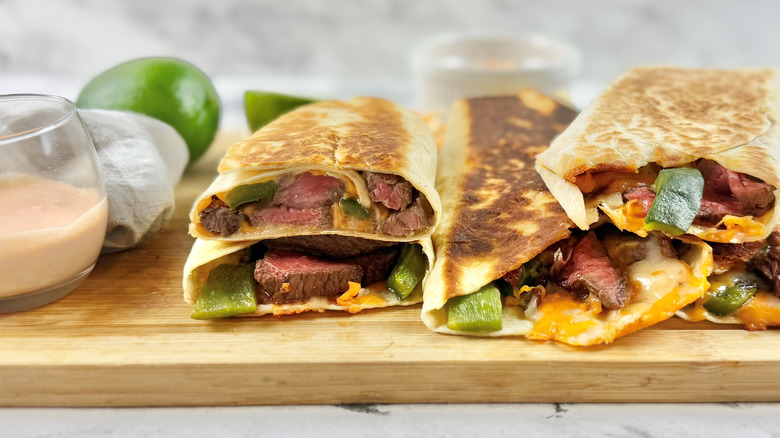 Steak and poblano rolled quesadillas on wooden board