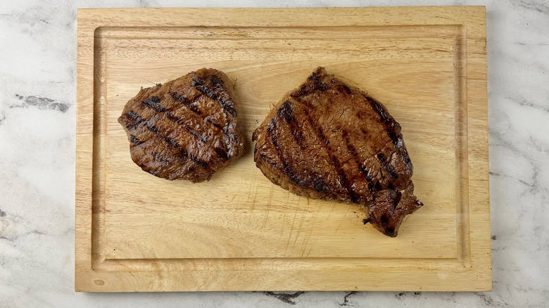 Grilled steaks on wooden board