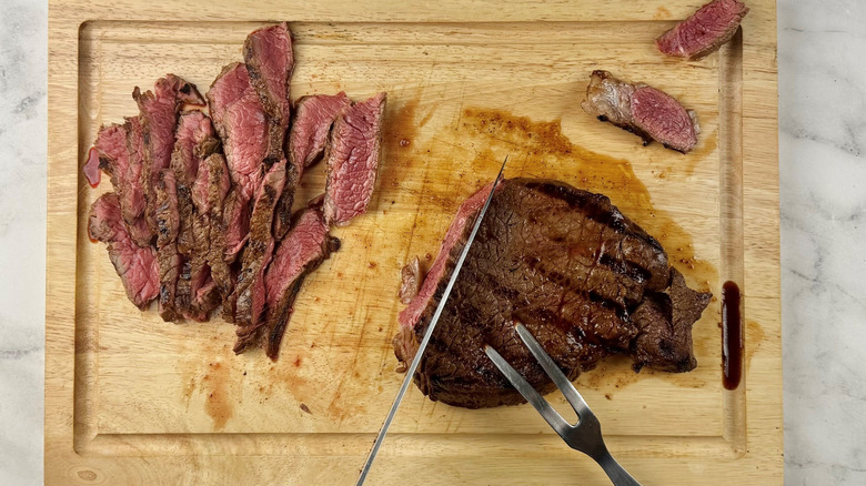Slicing steaks on wooden board
