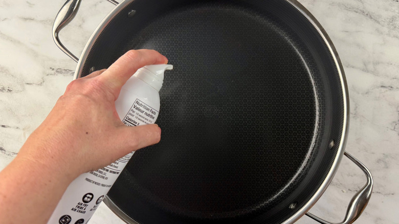 Hand spraying pan with cooking spray