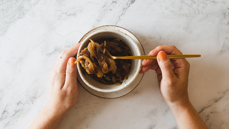 lifting onions with a spoon out a bowl