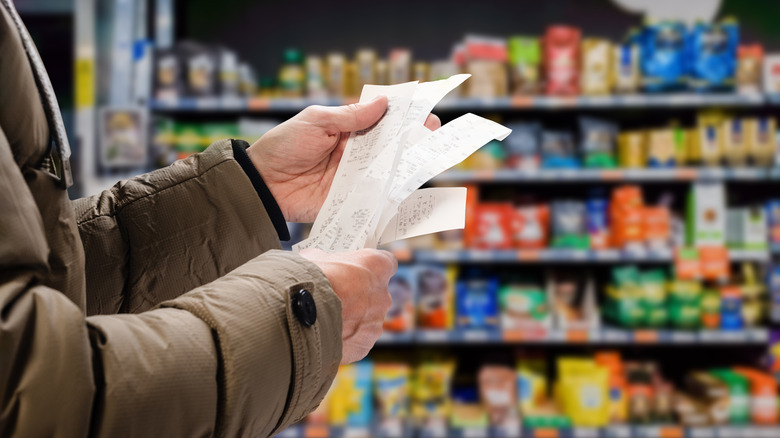 person looking at grocery bill