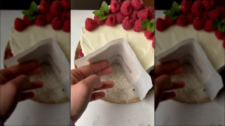 person preserving sliced cake with piece of parchment paper