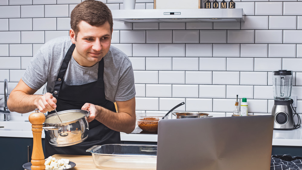 Man cooking recipe on laptop