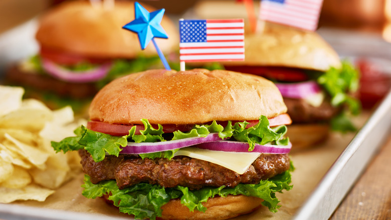 Cheeseburgers on a platter with American flag in the buns