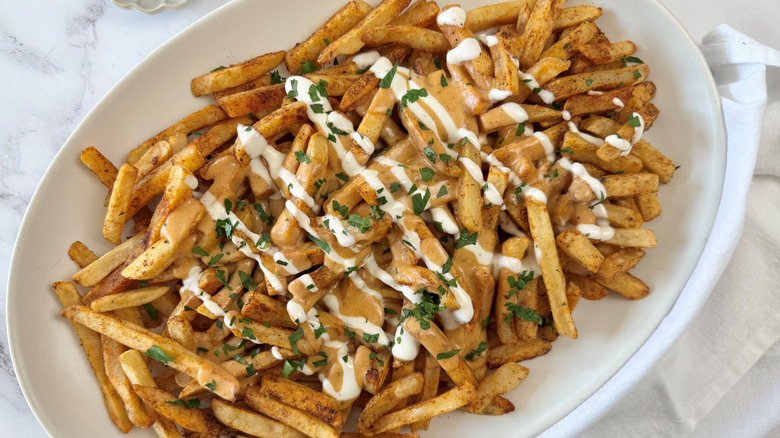 fries with cheese sauce, ranch dressing, and parsley