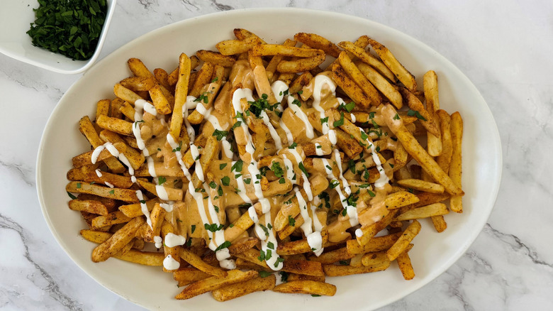 fries with cheese sauce, ranch dressing, and parsley