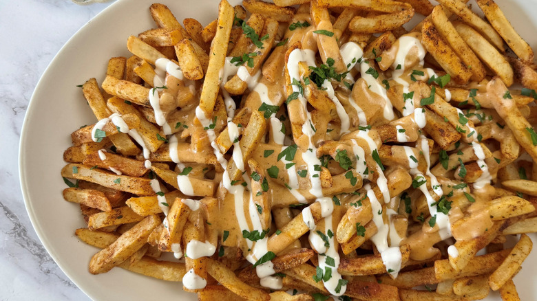 fries with cheese sauce, ranch dressing, and parsley