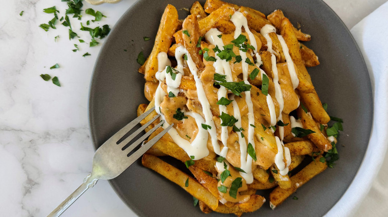 fries with cheese sauce, ranch dressing, and parsley