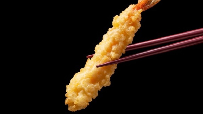 fried fish in wooden chopsticks