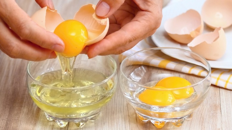 hands cracking egg over bowl