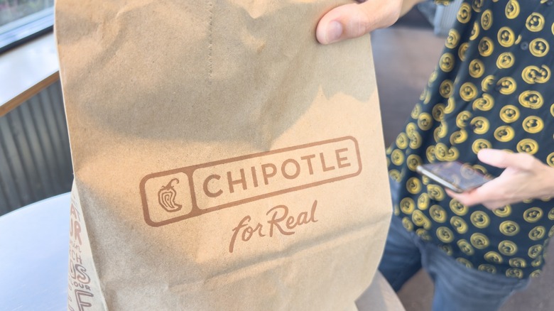 person holding Chipotle bag 