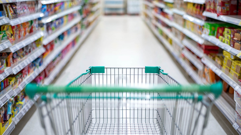 Green cart in grocery store aisle