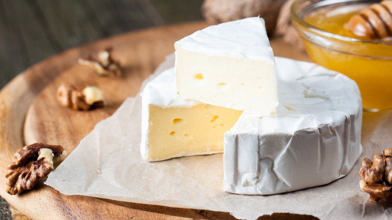 wheel of brie cheese on wooden plate