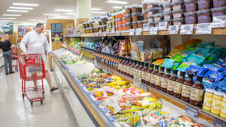 man grocery shopping with cart at trader joe's