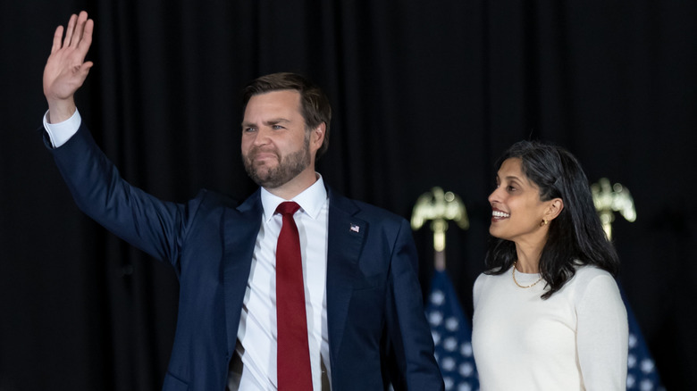 Usha and JD Vance smiling and waving at a rally