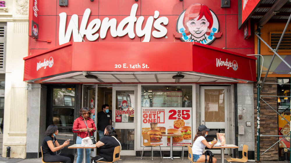 Customers sit outside a Wendy's restaurant