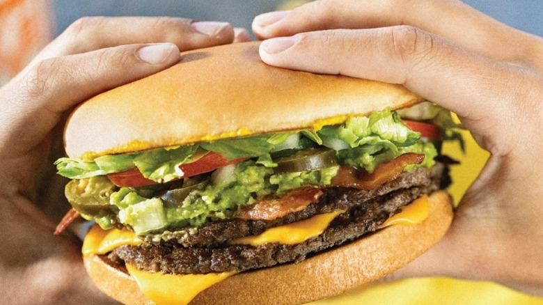 A person eating a Whataburger burger