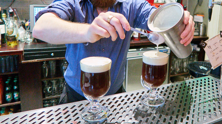 Pouring whipped cream into Irish coffee