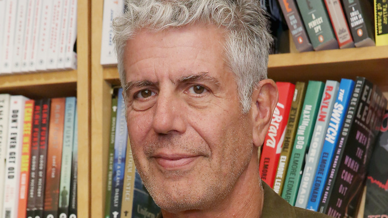 Anthony Bourdain close-up in front of bookshelf