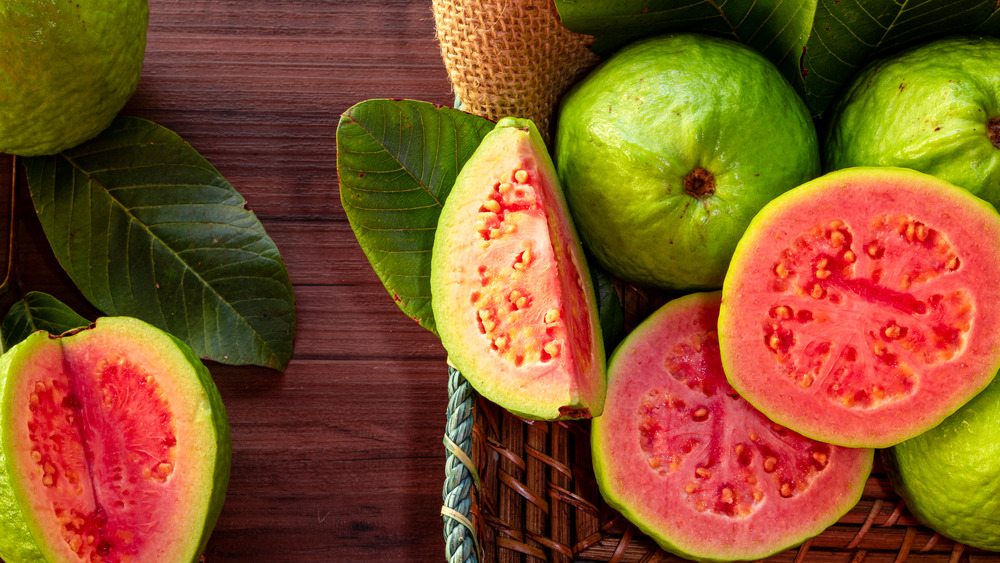 Several sliced guavas on wooden table