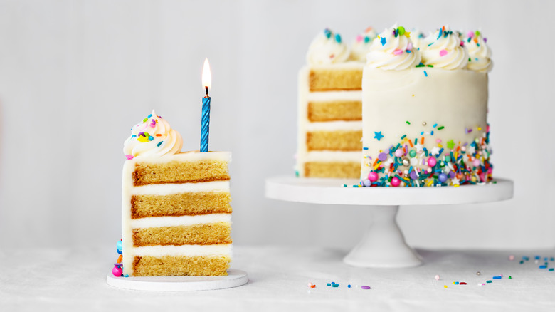 Dour layer yellow birthday cake with a candle in one slice