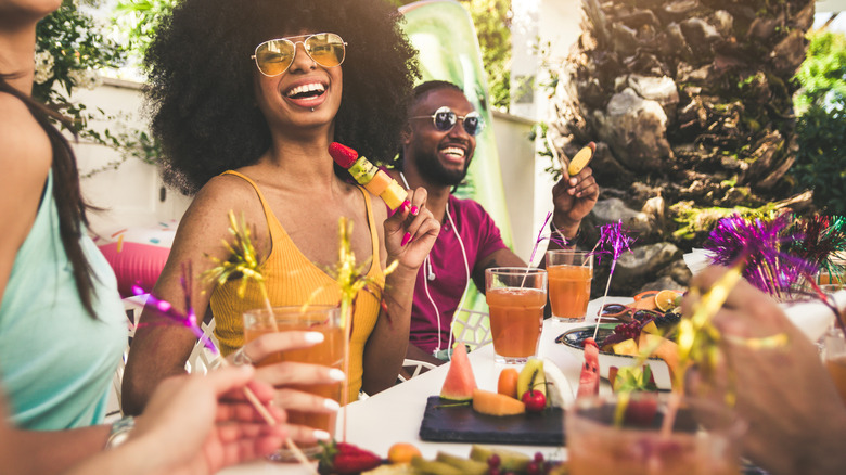 People laughing at a summer party with cocktails 