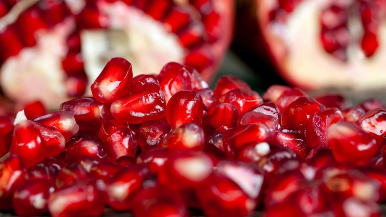 Pomegranate seeds with sliced pomegranates
