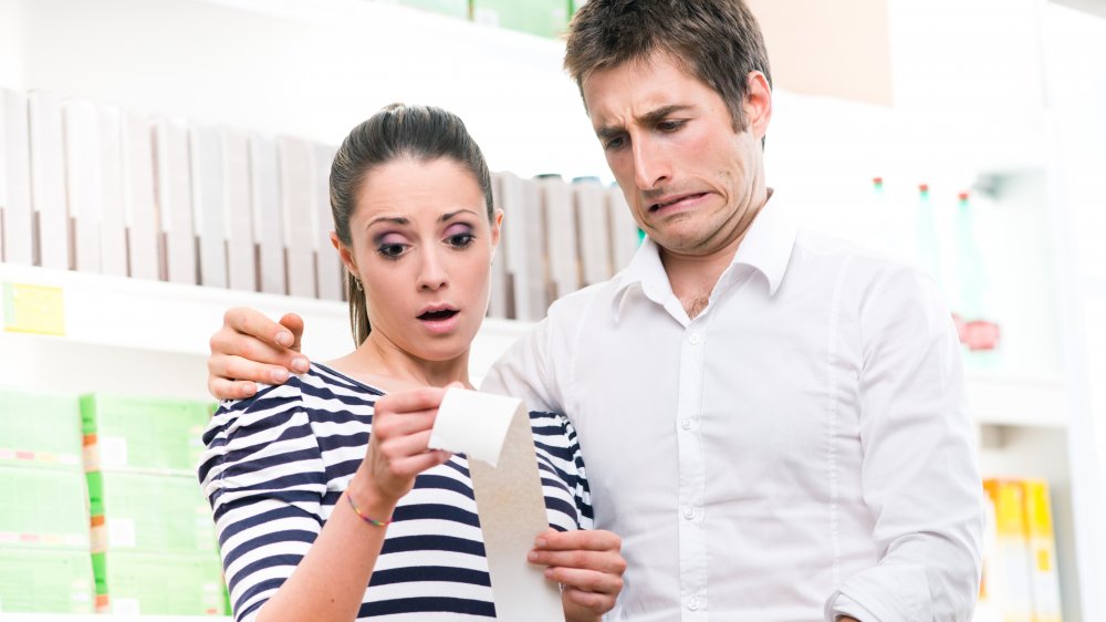 Couple looking at long Sam's Club receipt