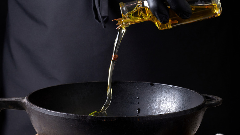 Pouring oil into cast iron skillet