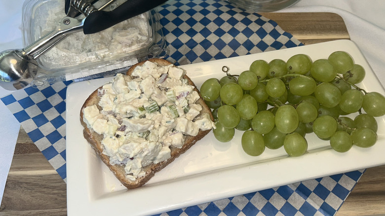 Whole Foods open-faced chicken salad sandwich on a white plate with grapes on the side
